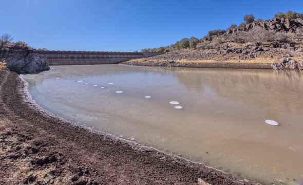 Shoreline view of Bainbridge Steel Dam in Kaibab National Forest, Ash Fork, Arizona, showcases historic landmark built in 1800s