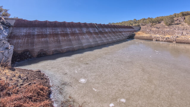Historic Bainbridge Steel Dam offers a view of its unique structure and surrounding landscape near Ash Fork Arizona in the Kaibab National Forest