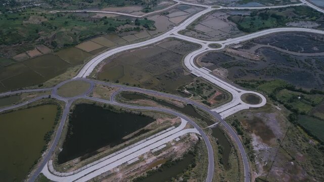 Drone Captures Construction. Overhead Shot Of Road Work. Elevated Perspective Showing Interchange Development Details. Aerial Overview Highlighting Roadway Layout And Surrounding Agriculture,Lombok