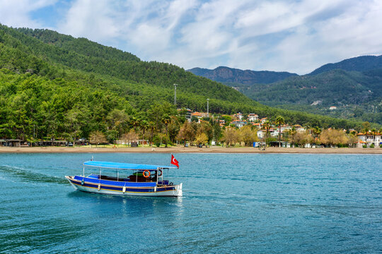 Tourist boat travels through turquoise water in Ekincik, a popular spot in Dalyan, Turkey