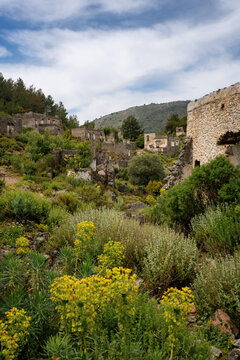 Exploring the abandoned houses of Kayakoy surrounded by lush vegetation in Fethiye Turkey