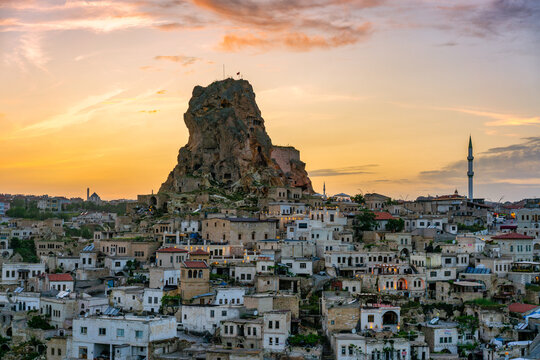 Sunset view of Ortahisar city with its castle and mosque set against the evening sky in Cappadocia, Turkey