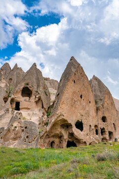 Selime ancient town features houses carved into rocks in Cappadocia Turkey during a sunny day with clouds