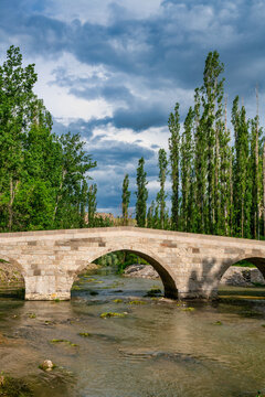 Selime stone bridge spans a river in Ihlara valley surrounded by nature in Cappadocia Turkey