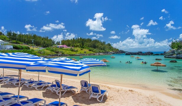 Enjoying a sunny day at Tobacco Bay with beach chairs and umbrellas in Bermuda&acirc;&euro;&trade;s clear waters