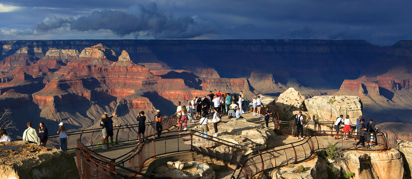 Visitors explore the South Rim of the Grand Canyon in Arizona during an afternoon with changing light