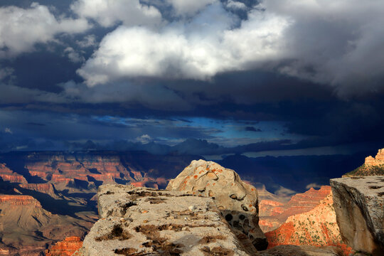 View of Grand Canyon from South Rim showing distant formations and cloudy sky during late afternoon light