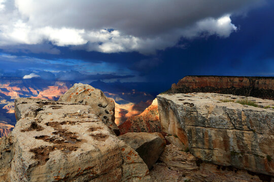 View of Grand Canyon from the South Rim shows rocky formations and dark sky over the landscape in Arizona, USA