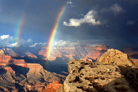 View of the Grand Canyon with rainbows appearing over the rock formations during afternoon light in Arizona, USA
