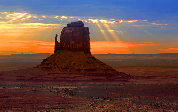 Sunrise over Monument Valley in Navajo Indian Territory, Utah with light beams shining on the rock formations