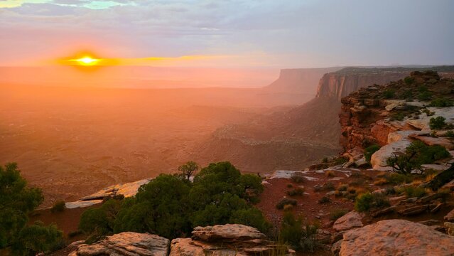 Sunset viewed from Grand View Point in Canyonlands National Park shows light spreading over desert landscape in Utah