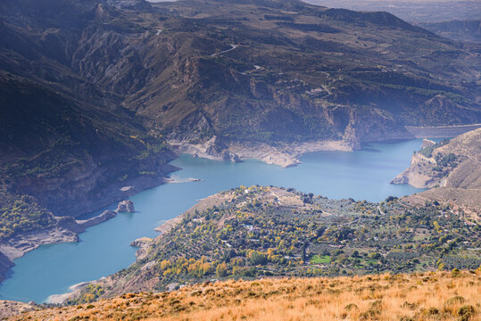 View over turquoise water of Guejar Sierra reservoir surrounded by mountain valleys in Sierra Nevada region located in Andalusia, Spain