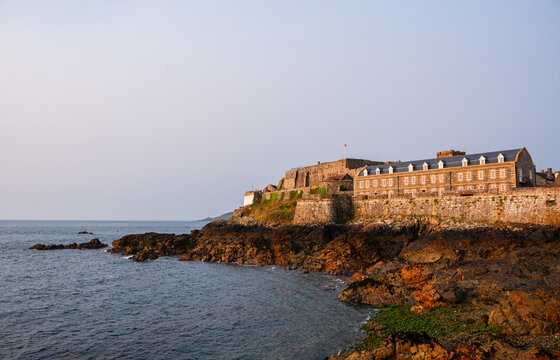 Castle Cornet Fortress stands on a rocky islet in the sea near Saint Peter Port in Guernsey Channel Islands at sunset