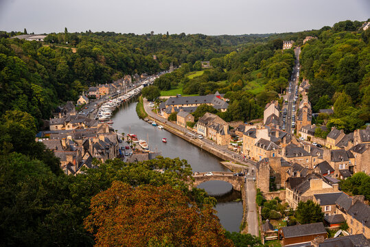 Aerial view shows the River Rance, stone houses, port, and bridge in Dinan, Brittany, France, capturing the layout of the town