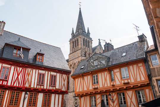 Vibrant half-timbered houses frame the spire of a cathedral in a historic setting of a city in France