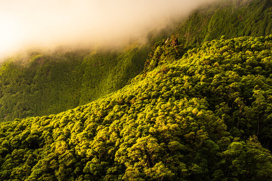 Low clouds drift over green highlands on Flores Island in Azores, Portugal during a clear day