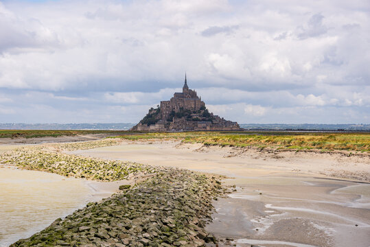 Mont Saint-Michel viewed from sandy tidal channels at low tide in Normandy, France