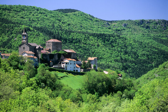 View of La Bastide-Pradines with green hills and trees during a sunny day in France's Occitanie region