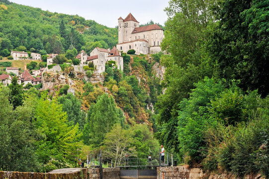 Locks along Lot River near a village in southwest France amidst trees and hills