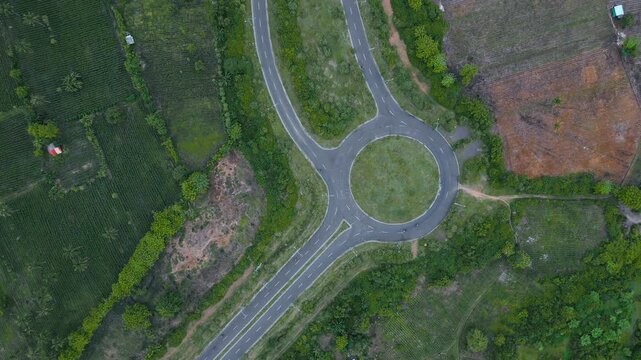 New Roundabout View. Greenbelt Roundabout With Surrounding Fields. Freshly Constructed Roundabout Amid Cleared Plots And Lanes. Aerial Perspective Of Recently Built Roundabout In Lush Green Areas