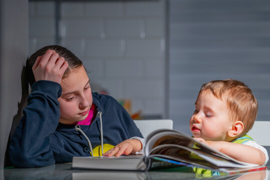 Real everyday moment of brother and sister reading together, expressing natural emotions, quiet bonding, and authentic unposed childhood experience.