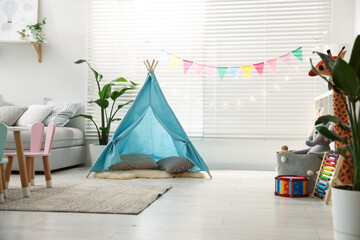 Child's room with toy wigwam, toys and colorful flags. Interior design © New Africa