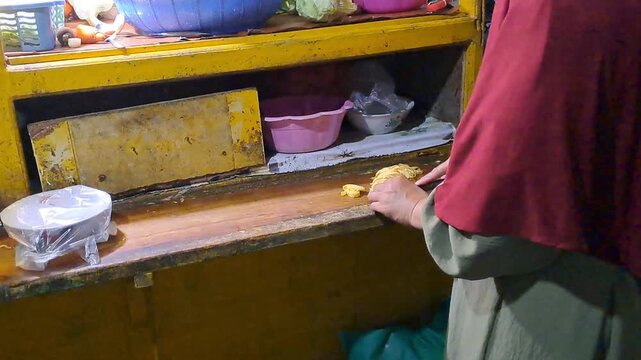 Horizontal shot of an Indonesian street food vendor preparing Capcay. Detailed process from chopping vegetables, stir-frying in a wok, adding toppings, to packaging for a customer.