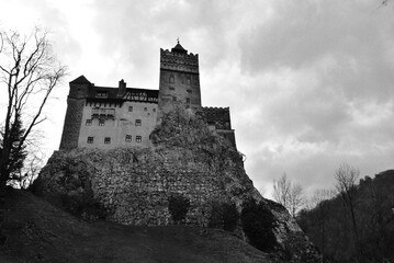 Fototapeta premium Vue en contre-plongée du Château de Bran, aussi appelé Château de Dracula, en noir et blanc.
