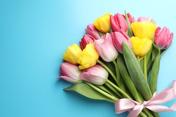 Fototapeta premium Beautiful colorful tulips on light blue background, top view. Space for text
