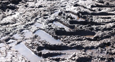 Naklejka premium Ground mud with tire tracks as background, closeup