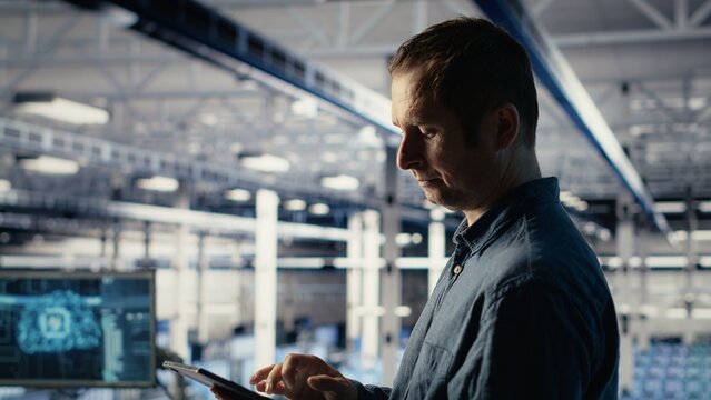 Data center software developers investigate neural networks configuration, making adjustments to ensure optimal function. Server farm workers use tablet to check deep learning error reports, camera B