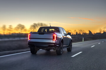 Modern pickup truck driving highway at sunset with motion blur. Pickup travel concept. © puhimec