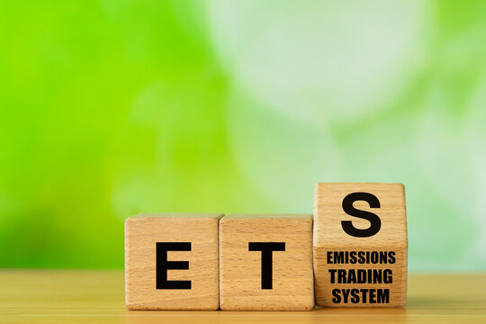ETS Symbol. Emissions Trading System on wooden blocks. The EU system for reducing greenhouse gas emissions. Cap and Trade. Business Environmental Concept. Copy space, Green background