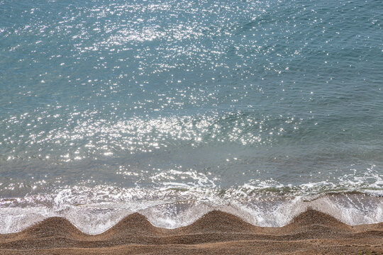 Looking down at beach cusps along the Jurassic coast, on a sunny day