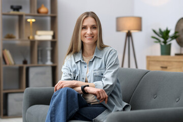 Obraz premium Portrait of smiling woman on sofa at home
