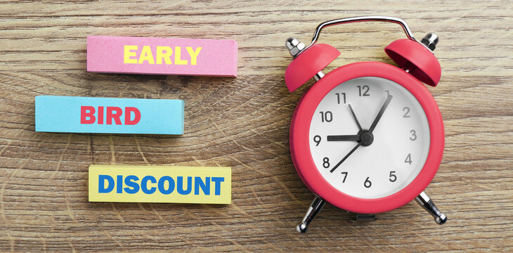 Early bird discount poster with alarm clock on wooden background. Banner design