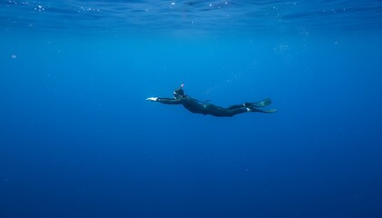 Fototapeta premium A person snorkeling in the clear blue ocean water with a serene underwater view