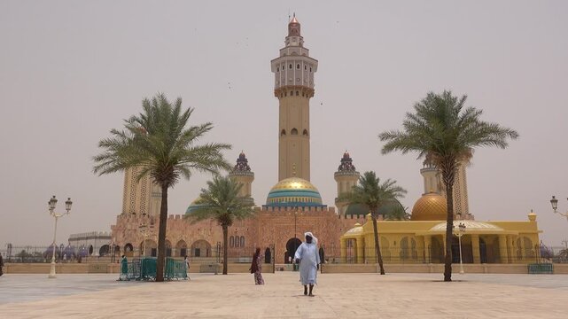 SENEGAL - 7.31.2025 - Ground level view of worshippers leaving and entering Senegal's Great Mosque Of Touba.