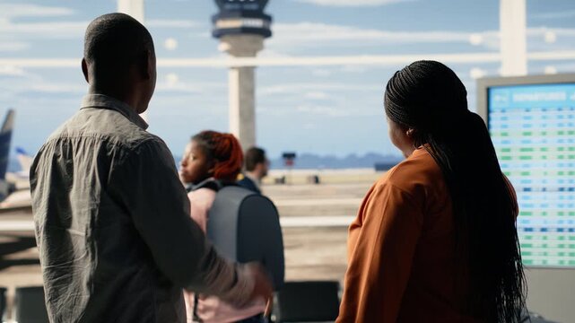 Proud parents thrilled about grown-up child independence as exchange student. Black cheerful mother and father stand in the terminal smiling and waving, embodying freedom and optimism.