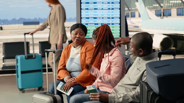 Airport departure lounge, black parents and girl, happy family of three excited in waiting area, preparing for international vacation together. Travelers ready to board plane for their fun journey.