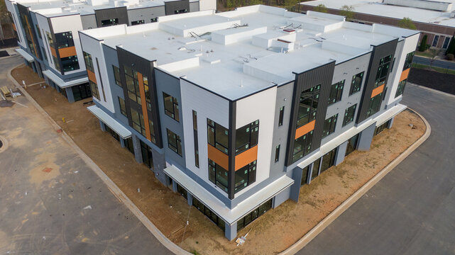 Aerial drone inspection of commercial TPO roof featuring heat-welded seams, HVAC curb flashing, and pipe penetrations.