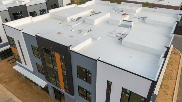 Aerial drone inspection of commercial TPO roof featuring heat-welded seams, HVAC curb flashing, and pipe penetrations.