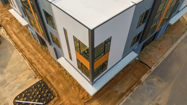 Aerial drone inspection of commercial TPO roof featuring heat-welded seams, HVAC curb flashing, and pipe penetrations.