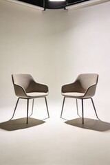 Fototapeta premium Two Minimalist Armchairs in a Bright Studio Setting with Soft Lighting and Shadows
