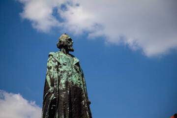 Fototapeta premium Bronze Statue Against Blue Sky Dramatic Perspective