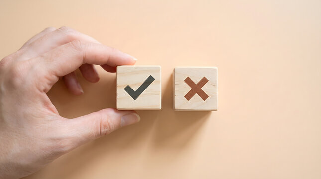 Hand selecting a wooden cube with a checkmark, next to a cube with a cross