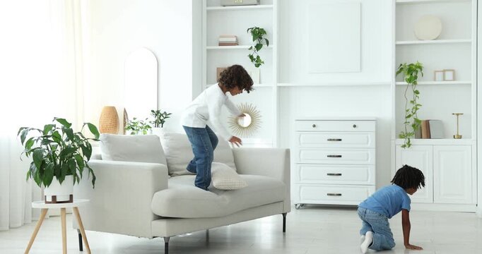 Cute little brothers having fun on sofa at home