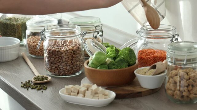 Woman with vegan products rich in protein at table indoors, closeup