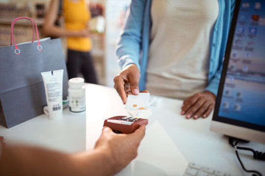 Customer paying with contactless card at pharmacy checkout counter