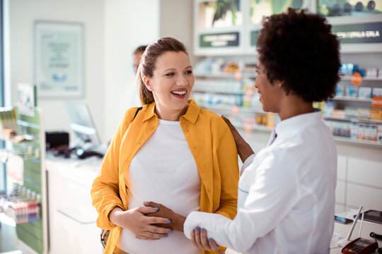 Woman consulting pharmacist in modern pharmacy